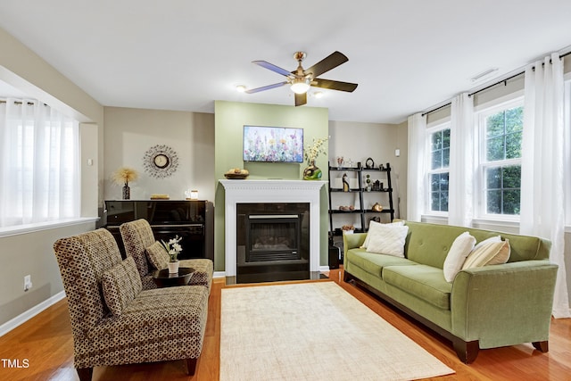 1141 Brookhill Way, Cary, NC 27519 - living area with wood finished floors, ceiling fan, a fireplace with flush hearth, and baseboards