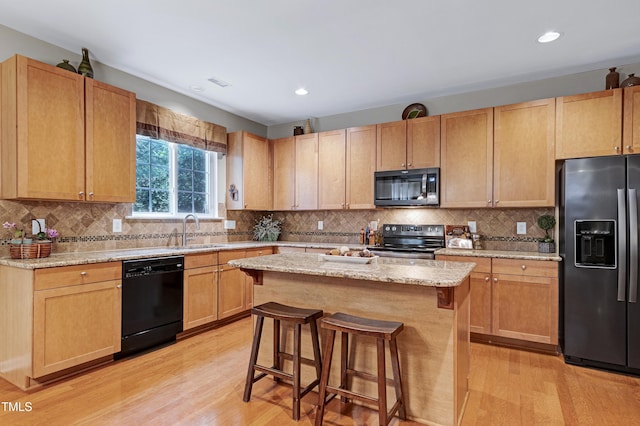 1141 Brookhill Way, Cary, NC 27519 - kitchen with appliances with stainless steel finishes, a sink, a kitchen breakfast bar, light wood finished floors, and light stone counters