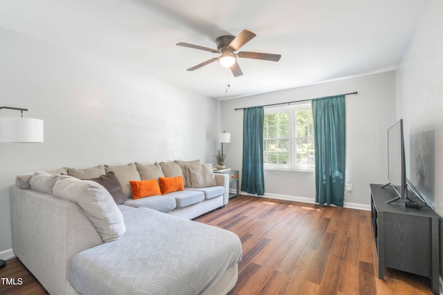 living room with a ceiling fan, wood finished floors, and baseboards