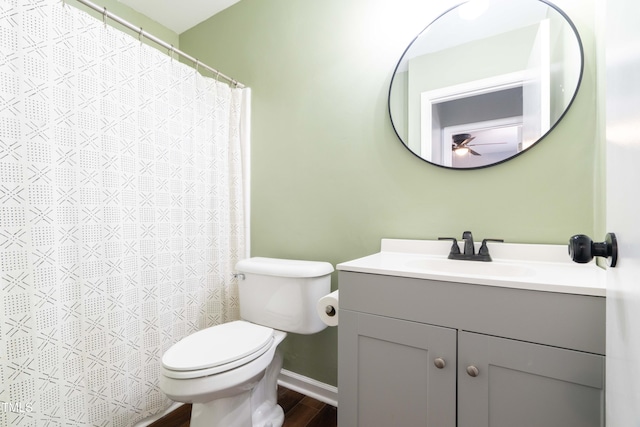 full bath featuring toilet, vanity, baseboards, wood finished floors, and a ceiling fan