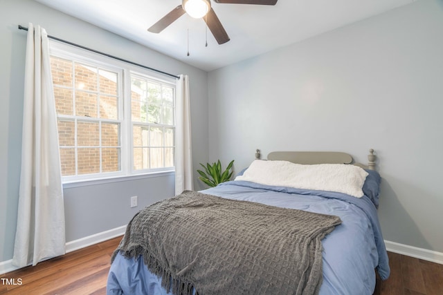 bedroom with baseboards, wood finished floors, and a ceiling fan