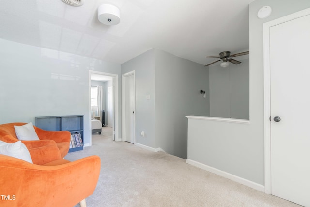 sitting room with carpet floors, ceiling fan, and baseboards
