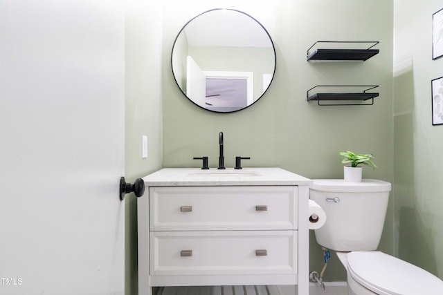 half bathroom featuring toilet and vanity
