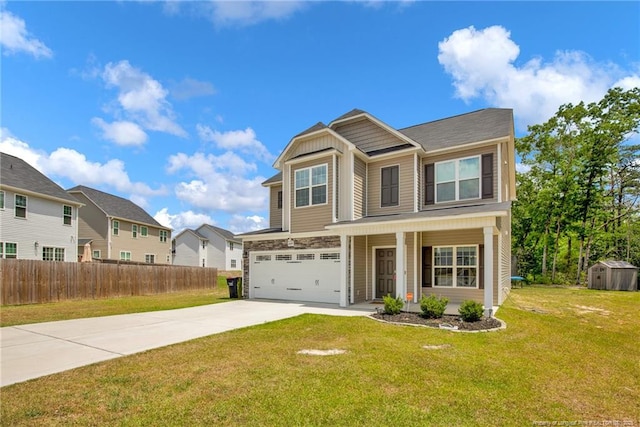 view of front of home featuring an attached garage, a storage shed, fence, a front lawn, and driveway