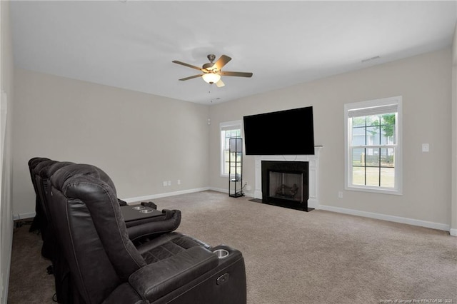 carpeted living room with visible vents, baseboards, a fireplace, and ceiling fan
