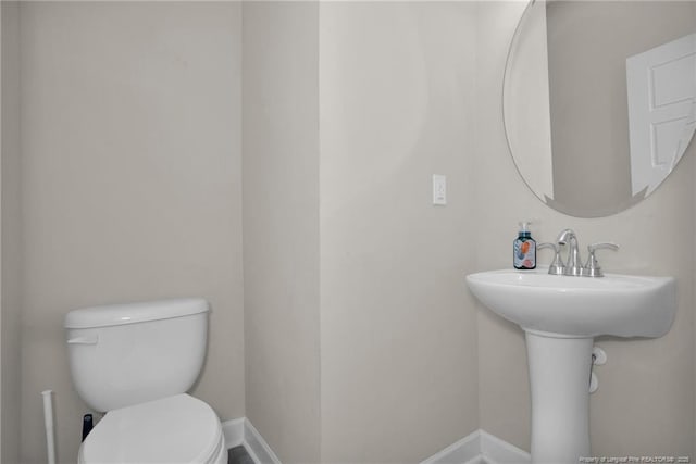 bathroom featuring toilet and baseboards