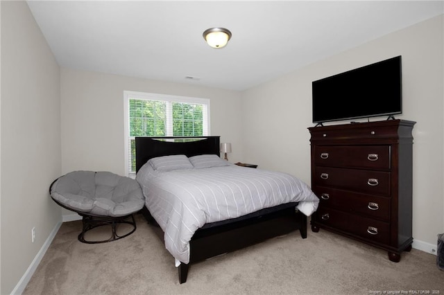 bedroom with light carpet and baseboards