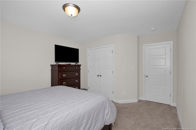 bedroom featuring carpet, baseboards, and a closet