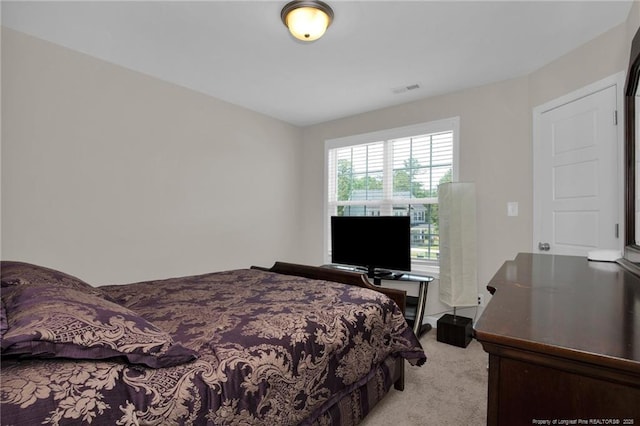 bedroom featuring light colored carpet and visible vents