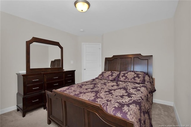 bedroom with light colored carpet and baseboards