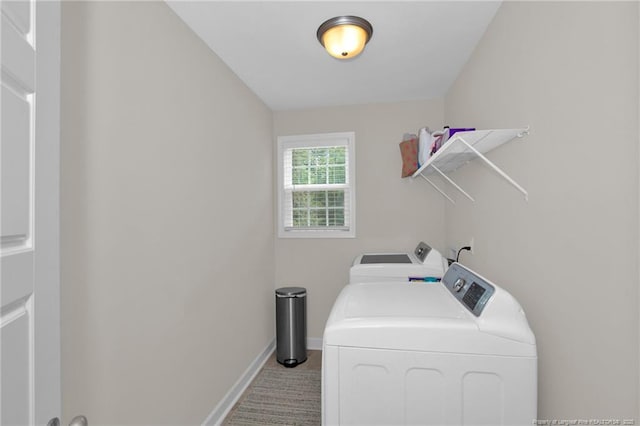 clothes washing area featuring washing machine and clothes dryer, baseboards, laundry area, and light colored carpet