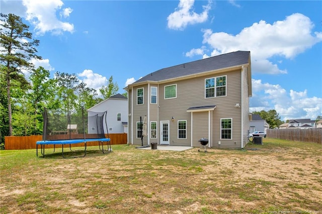 back of property with a yard, a trampoline, a patio area, and fence private yard