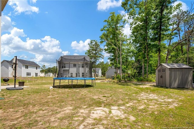 view of yard featuring a storage shed, a trampoline, and an outdoor structure