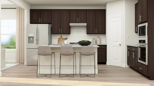 kitchen with oven, white fridge with ice dispenser, under cabinet range hood, dark brown cabinetry, and built in microwave