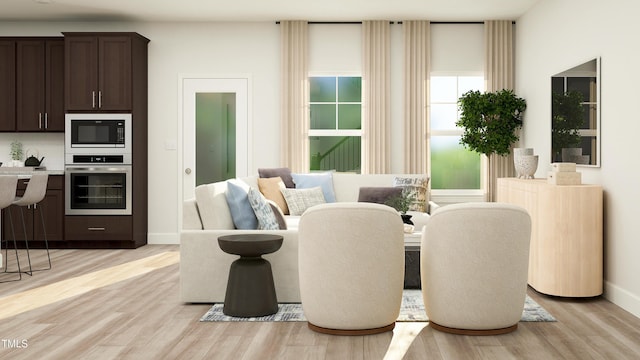 living area with baseboards and light wood-type flooring