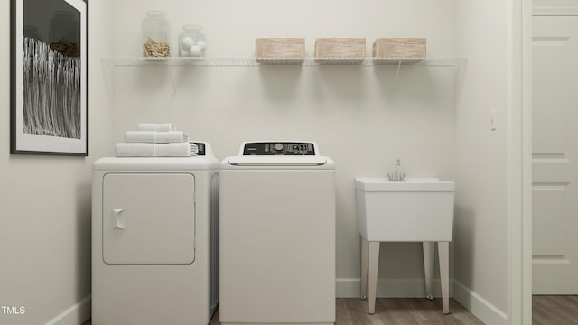 laundry room with washer and dryer, laundry area, wood finished floors, and baseboards