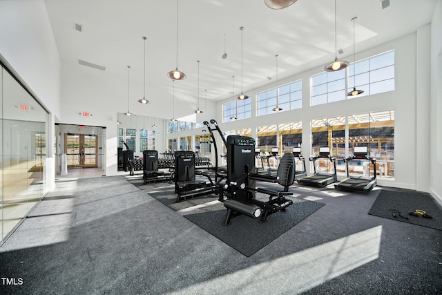 gym with french doors, visible vents, and a high ceiling