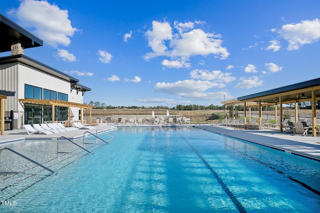 community pool with a patio area and fence