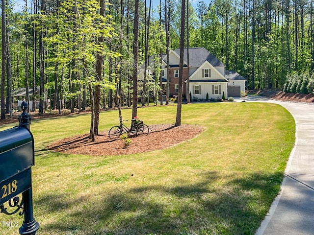 1218 Rogers Farm Rd, Wake Forest, NC 27587 - view of front of house featuring board and batten siding, driveway, a garage, and a front yard