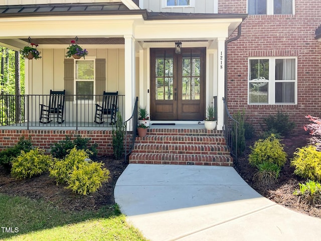 1218 Rogers Farm Rd, Wake Forest, NC 27587 - property entrance featuring board and batten siding, a porch, french doors, a standing seam roof, and brick siding