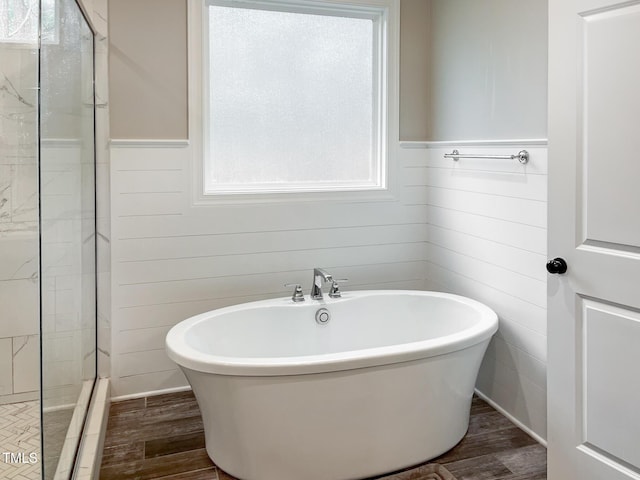1218 Rogers Farm Rd, Wake Forest, NC 27587 - bathroom featuring a tile shower, wood finished floors, a freestanding tub, and a wainscoted wall
