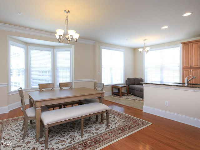 dining room with a chandelier, plenty of natural light, wood finished floors, recessed lighting, and baseboards