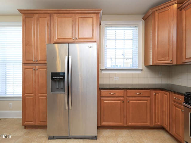 kitchen with stainless steel appliances, tasteful backsplash, brown cabinets, and baseboards