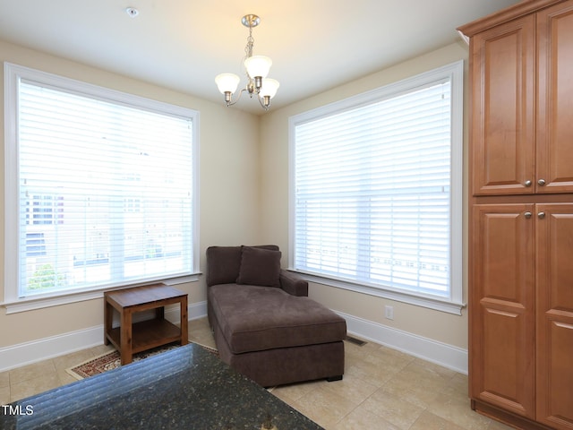 sitting room featuring a chandelier, baseboards, and light tile patterned flooring