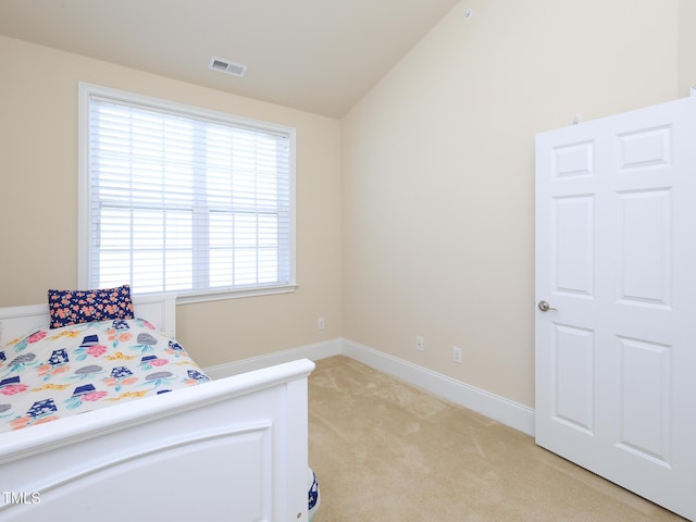 bedroom with light carpet, vaulted ceiling, and baseboards