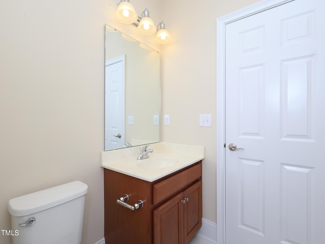 half bath featuring vanity and toilet