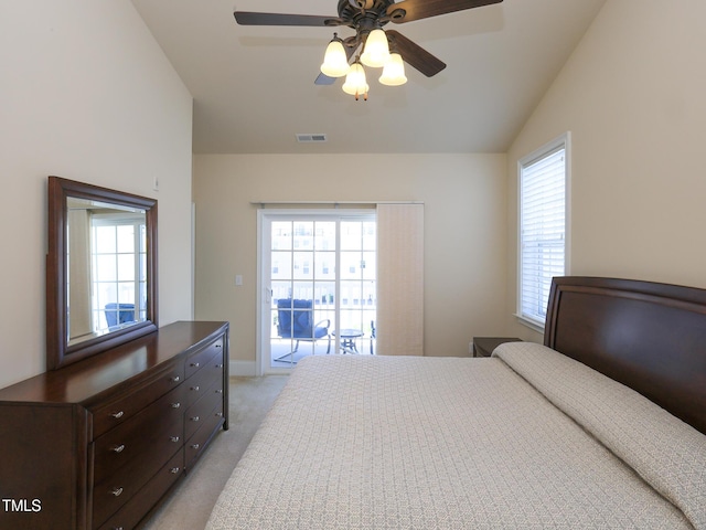 bedroom with vaulted ceiling, light colored carpet, multiple windows, and access to exterior