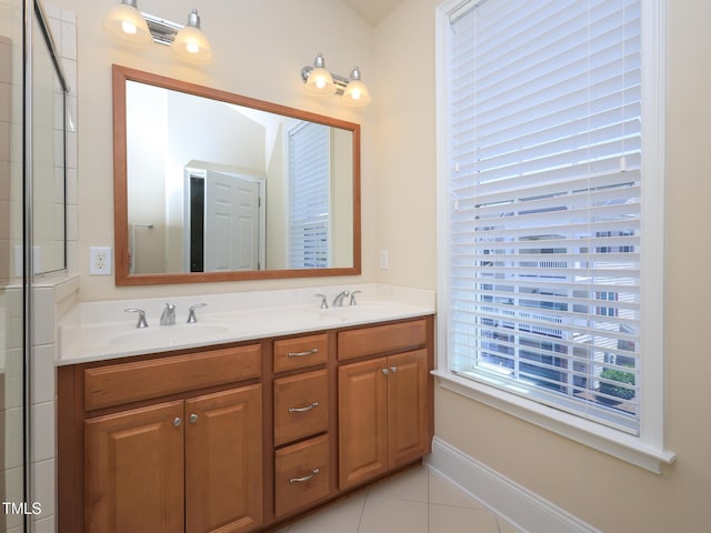 full bath featuring double vanity, tile patterned flooring, and baseboards