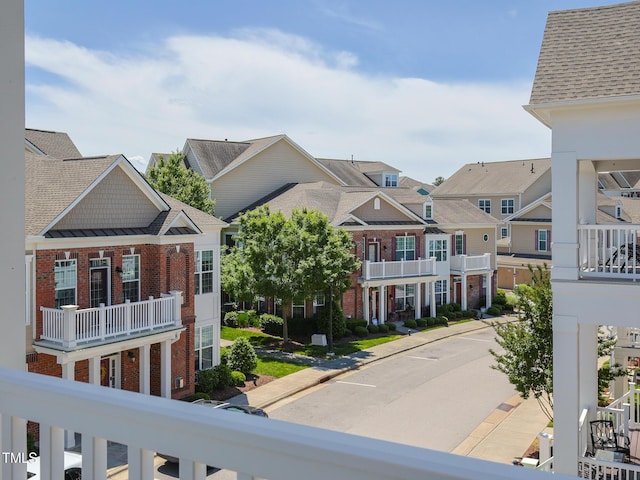 view of asphalt street featuring a residential view and curbs