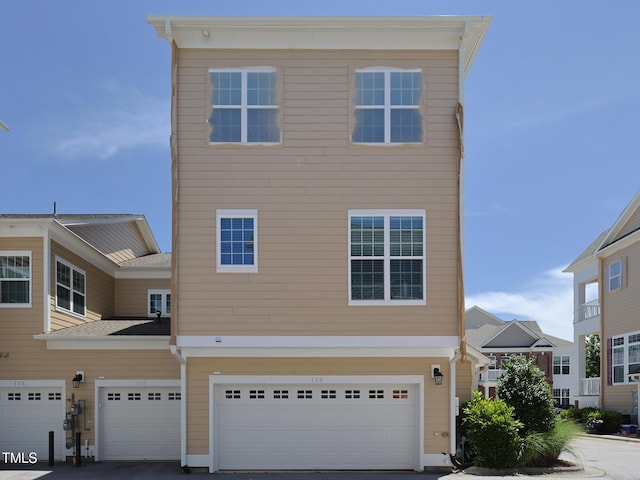 multi unit property featuring a garage and driveway