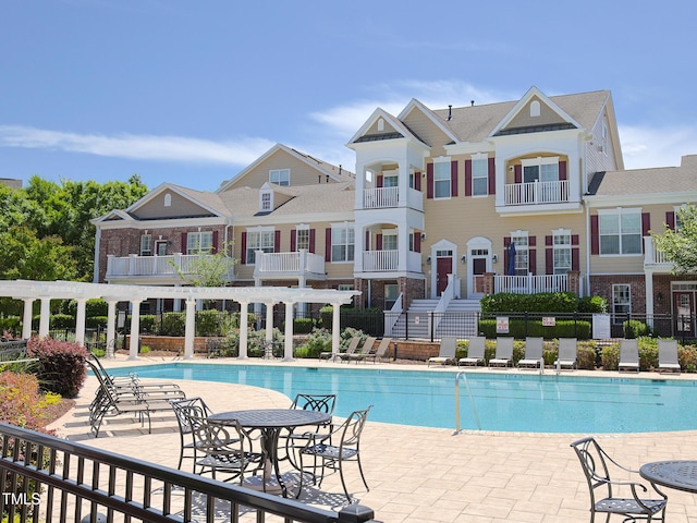 community pool with a pergola and fence