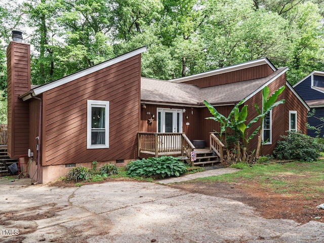 view of front of home with a chimney, roof with shingles, and crawl space