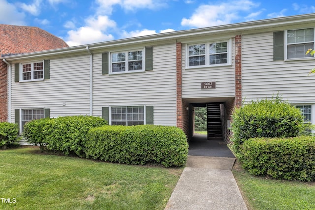 townhome / multi-family property featuring a front lawn