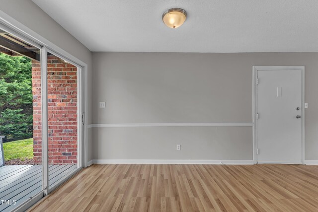 empty room featuring light wood-type flooring and baseboards