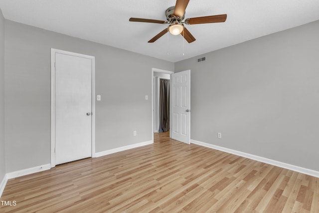 unfurnished bedroom featuring light wood-style floors, baseboards, and ceiling fan