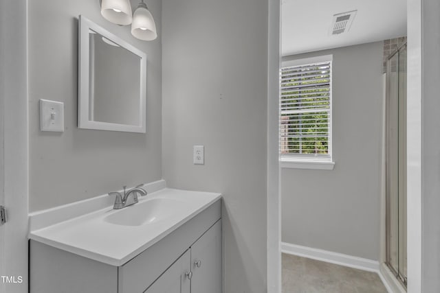 bathroom with vanity and a shower with door