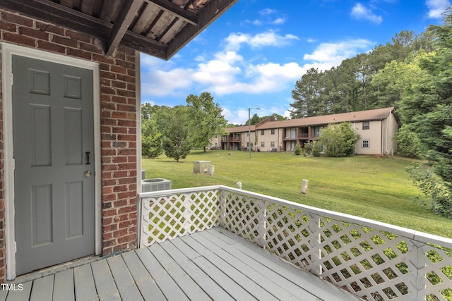 wooden terrace with a yard and central AC unit