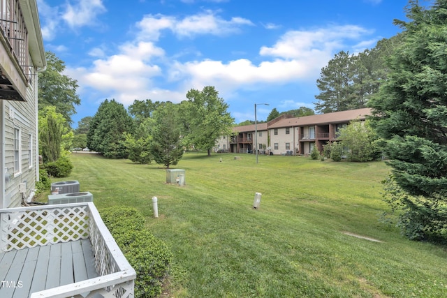 view of grassy yard with central AC