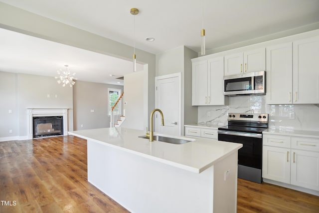 509 Olive Branch Rd, Durham, NC 27703 - kitchen featuring appliances with stainless steel finishes, a sink, wood finished floors, and a kitchen island with sink