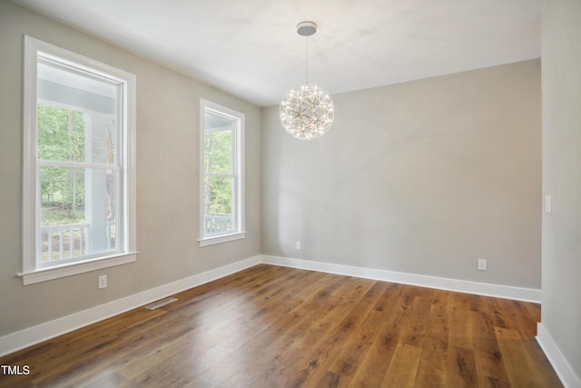 509 Olive Branch Rd, Durham, NC 27703 - empty room featuring a chandelier, baseboards, and wood finished floors