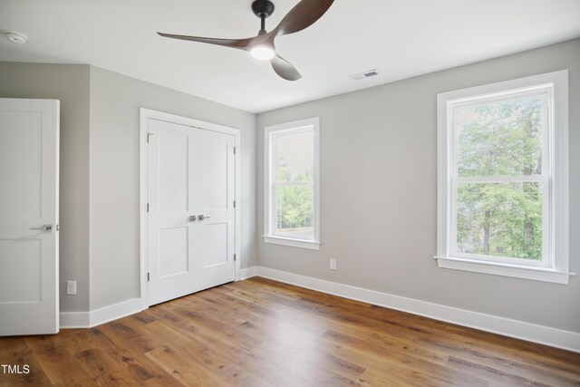 509 Olive Branch Rd, Durham, NC 27703 - unfurnished bedroom with baseboards, wood finished floors, a ceiling fan, and a closet