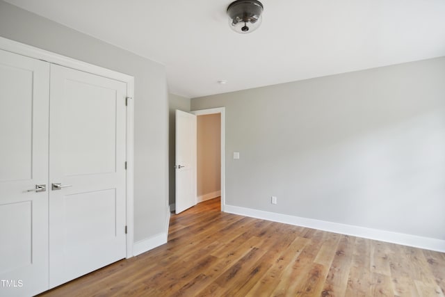 509 Olive Branch Rd, Durham, NC 27703 - unfurnished bedroom featuring baseboards, wood finished floors, and a closet
