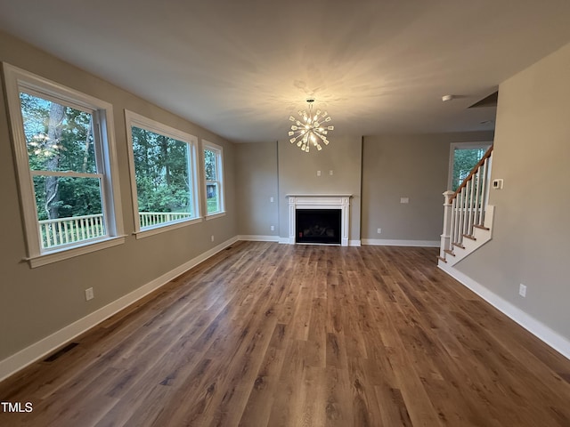 509 Olive Branch Rd, Durham, NC 27703 - unfurnished living room with healthy amount of natural light, wood finished floors, a chandelier, and baseboards