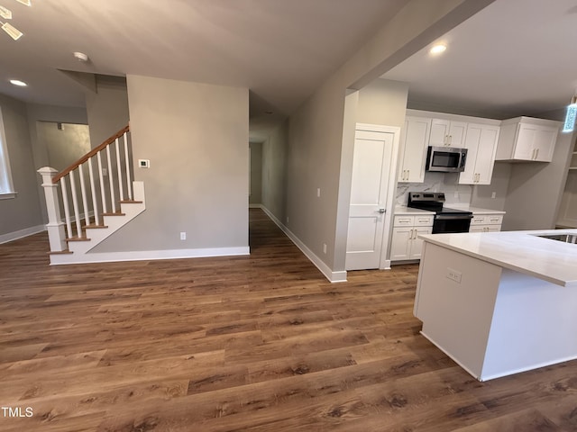 509 Olive Branch Rd, Durham, NC 27703 - kitchen with stainless steel appliances, baseboards, dark wood-style floors, white cabinetry, and light countertops