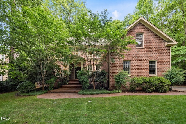 view of front of property with a front yard and brick siding