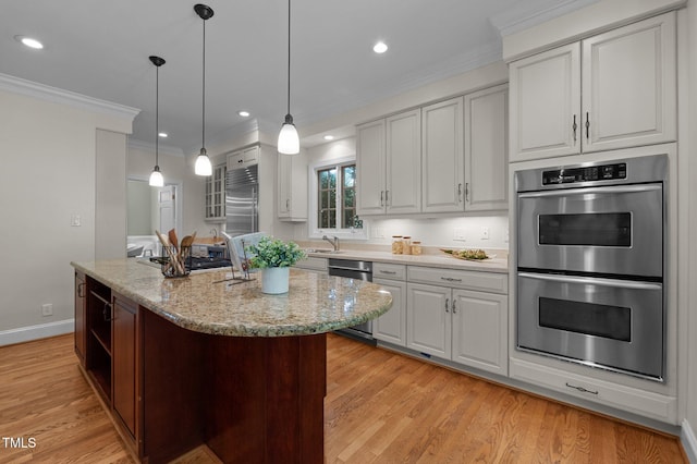 kitchen with stainless steel appliances, a center island with sink, light wood finished floors, light stone counters, and pendant lighting